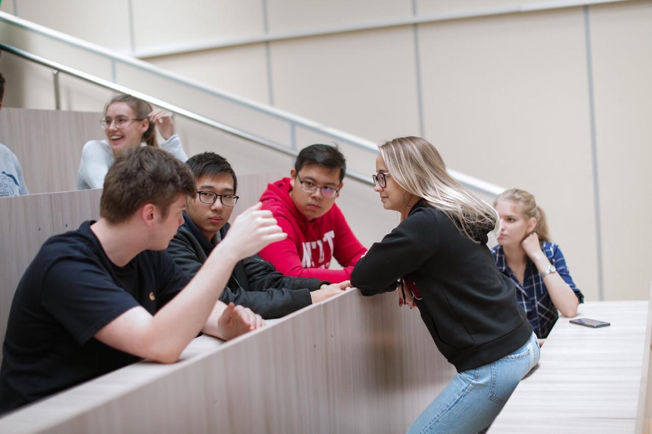Students talking in a tiered lecture hall