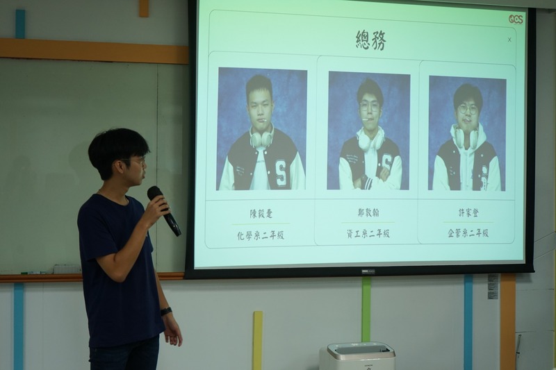 鄭敦翰進行總務報告，說明活動物資準備、機動人員協助、資產與器材管理、社辦維護及餐點訂購等工作內容。🛠️📦✨圖片