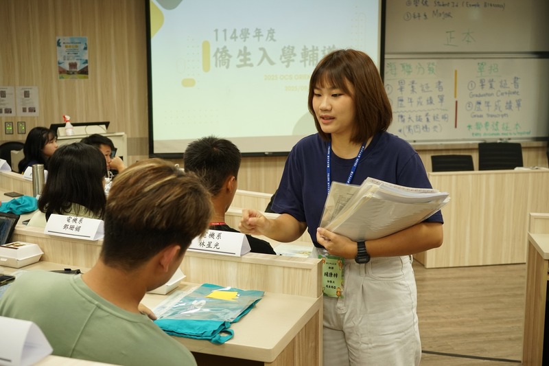 接待人員正逐一收取新生畢業文憑，完成入學報到手續。📄🎓✨圖片